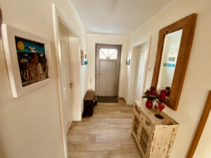 Zweiter Flur im Ferienhaus Haus Feuerstein auf Rügen mit Blick ins Wohnzimmer mit Kamin