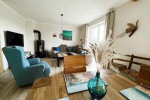 Gemütliches Wohnzimmer im Ferienhaus Haus Feuerstein mit Sofa, Essbereich und Kaminofen auf Rügen